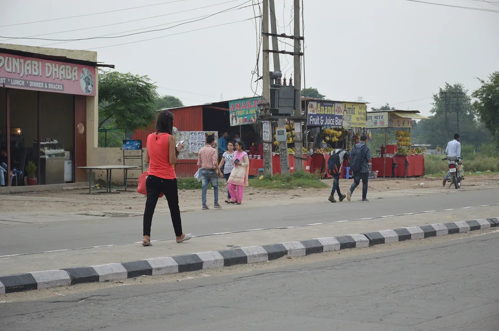 मोबाइल और लैपटॉप पर टैक्स दस्तावेज़ मिलाता व्यक्ति